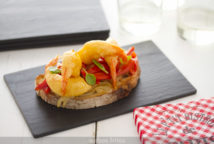 Tosta de cebolla, pimientos y langostinos